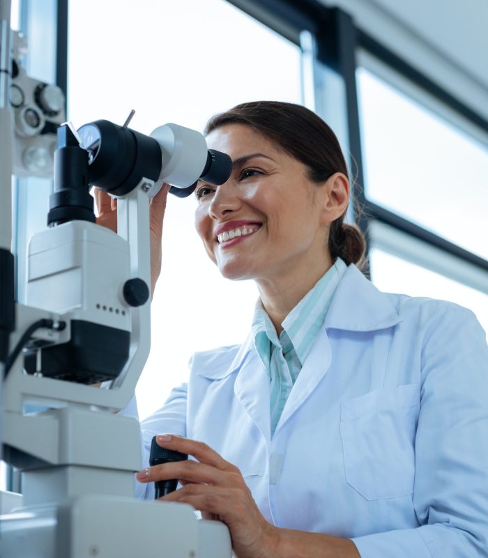 cheerful-female-doctor-looking-into-the-microscope.jpg
