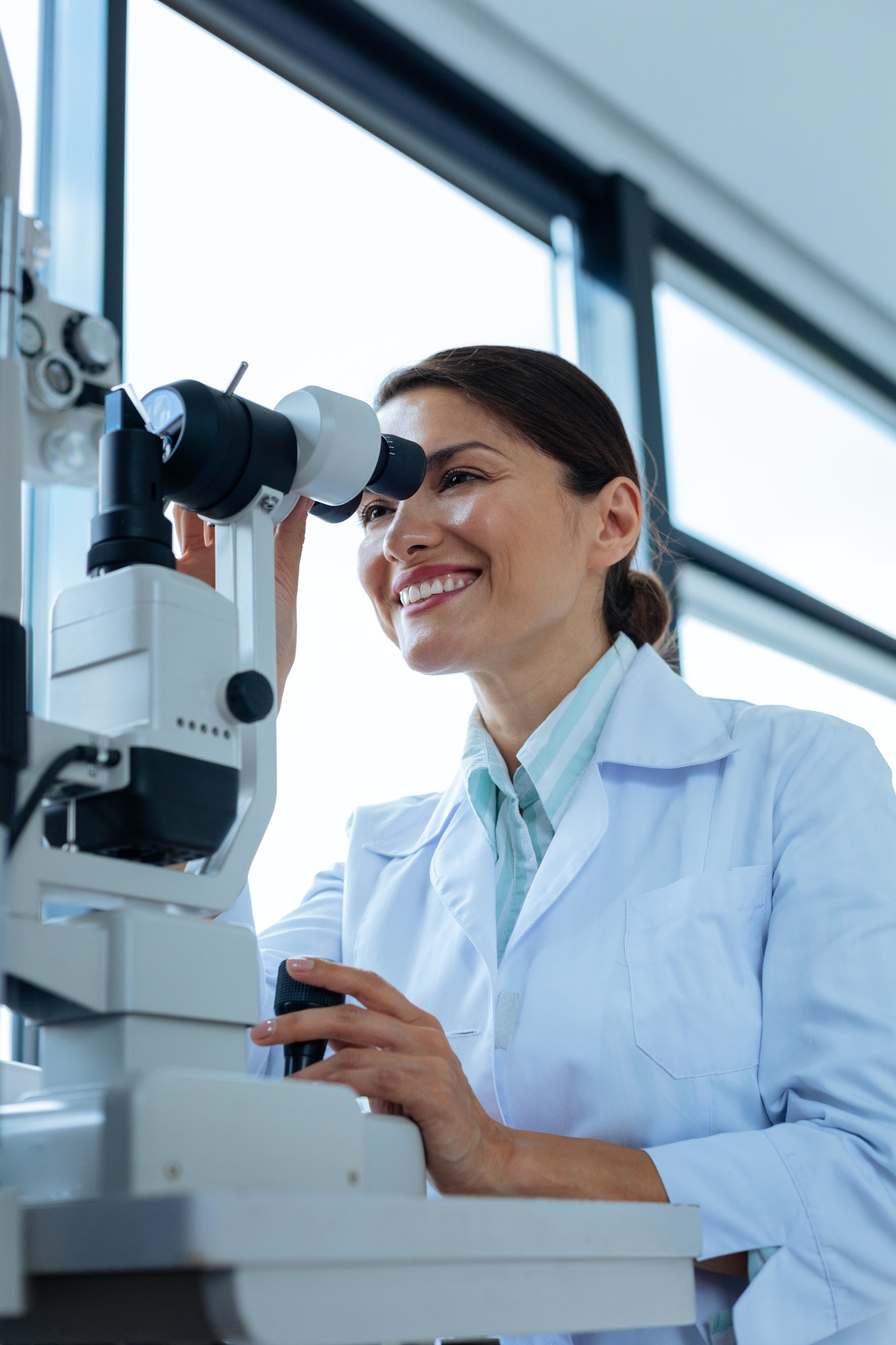 cheerful-female-doctor-looking-into-the-microscope.jpg